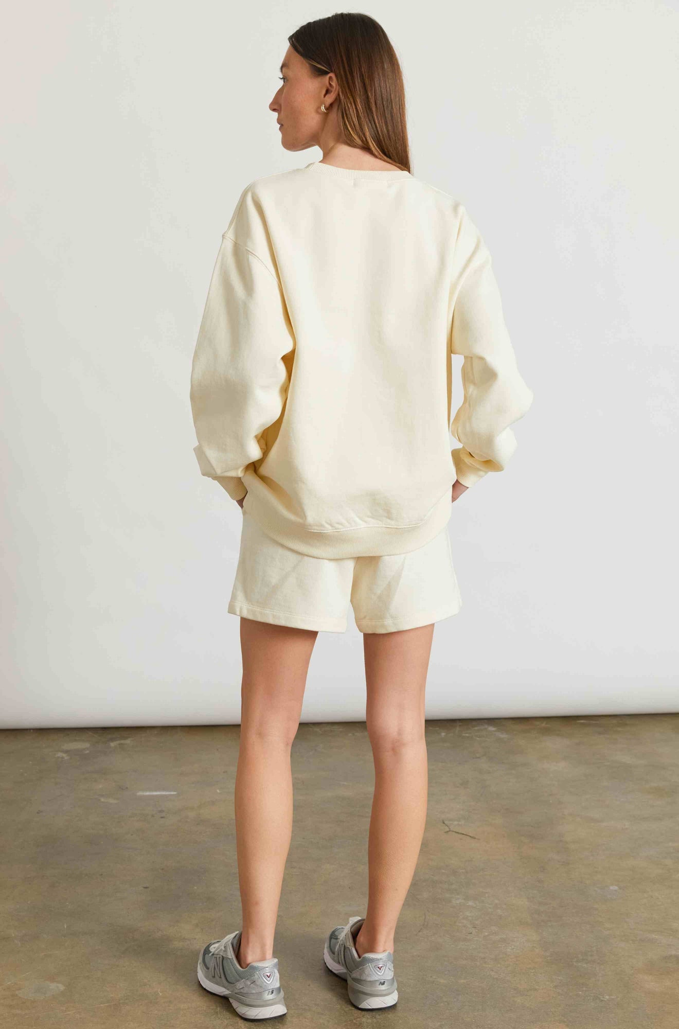 Woman wearing a yellow sweatshirt and matching sweatshorts