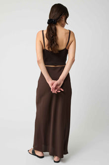 Woman wearing a brown dress with a plain white background