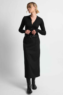 Woman wearing a black outfit on a light grey background