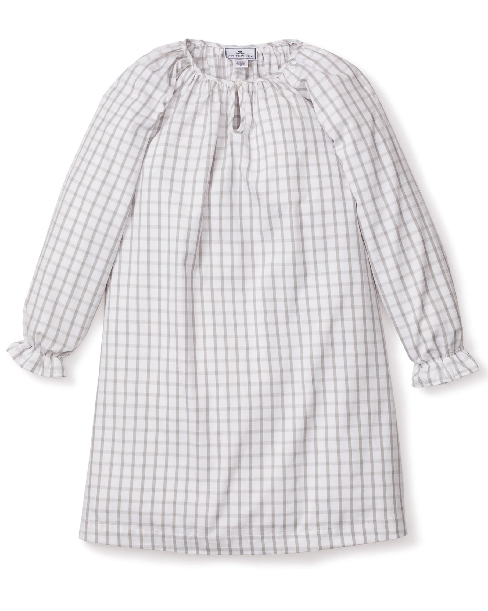 The Girls Twill Delphine Nightgown in Regent Tattersall by Petite Plume is a knee-length, long-sleeved dress with a gray and white checkered pattern. Made from yarn-dyed cotton, it has a round neckline with a keyhole opening and ruffled cuffs. The soft, lightweight fabric is ideal for casual wear.