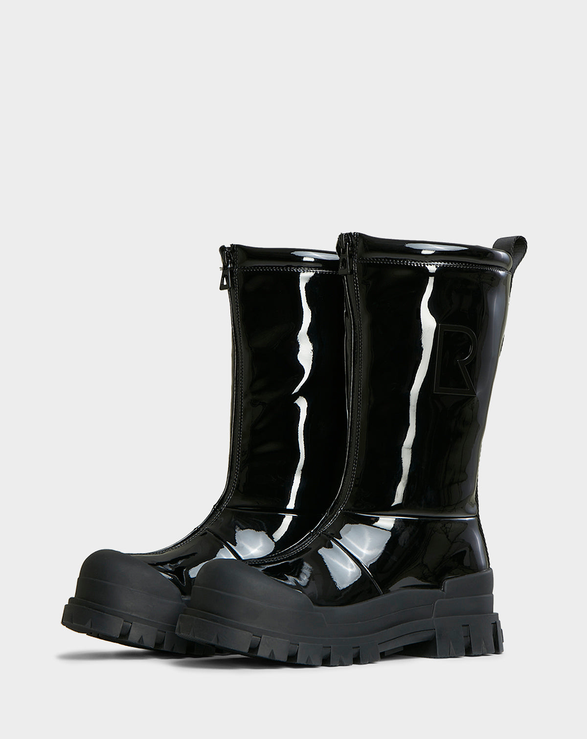 The KRISTAL HI - 8222510 BLACK winter boots by Rudsak feature a shiny black high-gloss finish, chunky grip soles, and front zippers, displayed side by side on a plain light background.