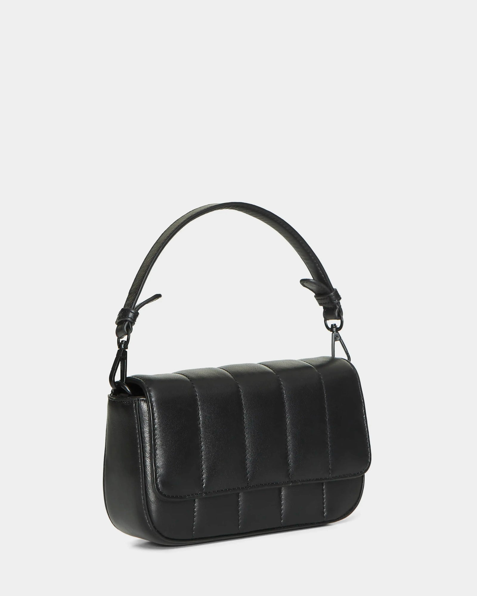 The Rudsak CHARLI X - 8324009 Black is a black, rectangular convertible crossbody bag with a short curved handle and vertical stitch detailing on the flap, shown against a plain white background.