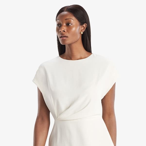 Grid image of a woman standing wearing the Nejvi Top in alabaster | Exclude