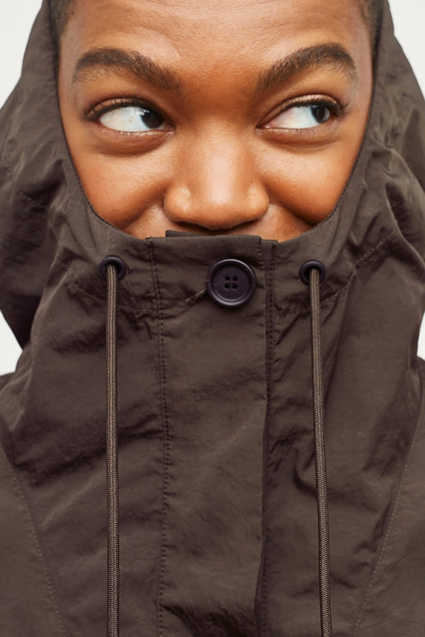 Detail image of a woman standing wearing the Britt Hoodie—AirTech in Dark Moss | Grid Hover | Exclude