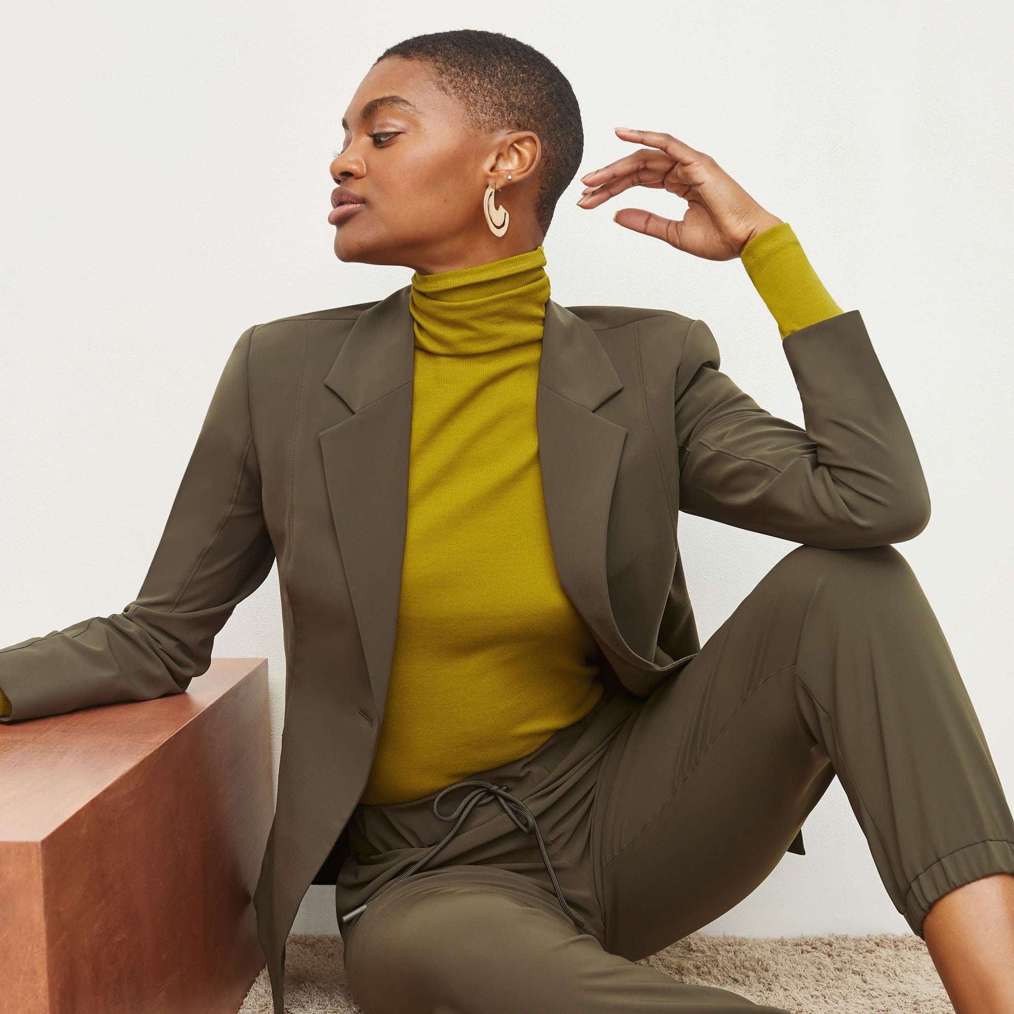 Front image of a woman standing wearing the Delaney Jogger—OrigamiTech in Olive | Exclude